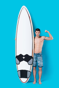 Surfer holding a surfboard showing his power