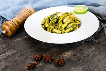 Pasta with pesto sauce and nuts on a the table