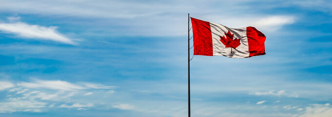 Panorama of Canada Flag against a blue sky