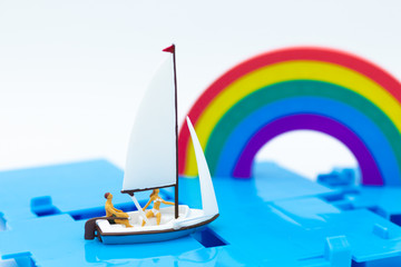 Miniature people : Tourist ride ship along the rainbow. Image use for travel concept.