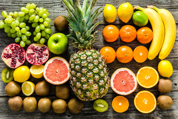 Table with fruit, tropical variety of assorted fruits on wood, healthy food and clean eating concept