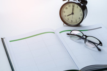 business reminder concept with Appointment book, alarm clock, glasses