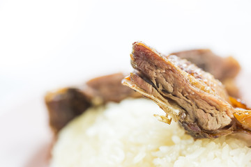 Grilled duck with crispy skin and sticky rice in a restaurant.