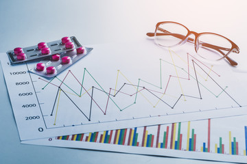 drug, pills and glasses with stethoscope on lab table