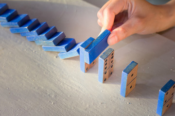Businessman stop domino effect. Risk management  concept, leadership has solution for problem.