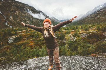 Happy woman raised hands walking in forest mountains enjoying view Travel adventure lifestyle...
