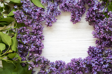 A bouquet of lilac flowers on a white wooden background. Mothers Day. Top view. From above. Copy space.