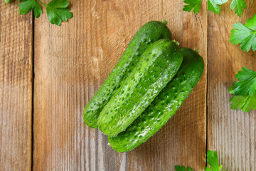 Fresh green homemade cucumber with parsley on an old wooden table.