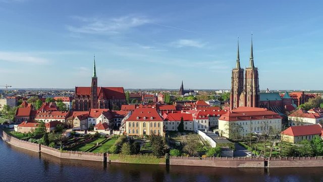 Poland. Wroclaw. Ostrow Tumski, Gothic cathedral of St. John the Baptist,  Collegiate Church of the Holy Cross and St. Bartholomew, park, and Odra (Oder) River. Aerial 4K reveal footage at sunset