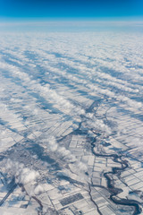 Fototapeta na wymiar Unusual clouds above snowy fields and curved river. Russia. Winter.