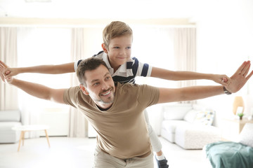 Obraz premium Cute little boy and father playing together at home