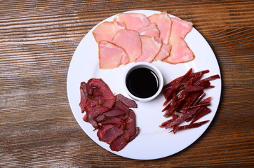 The board with homemade beef jerky - dried spiced meat, big glass of beer and bottle opener on...