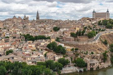 Fototapeta na wymiar Landscape of Toledo, Spain, with Alcazar, Cathedral, the river Tajo and a dramatic sky with clouds. 