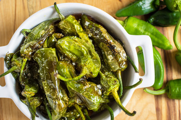 Fried Green Padron Peppers in White Bowl. Pimientos de Padron.
