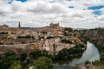 Fototapeta na wymiar Landscape of Toledo, Spain, with Alcazar, the river Tajo and a dramatic sky with clouds. 