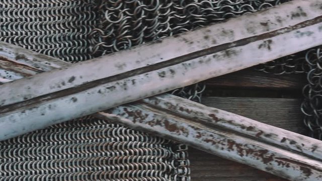Crossed swords on chain armor, close up, historical ancient weapon concept