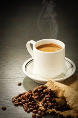 Cup of coffee full of coffee beans.