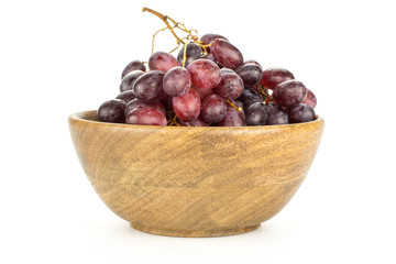 Red globe grape cluster in a wooden bowl isolated on white background fresh shiny dark pink berries.