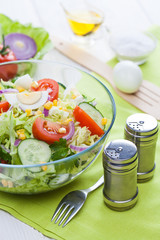 fresh spring salad of vegetables on a white wooden table.