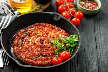 Barbecue sausages in frying pan on wooden table. 