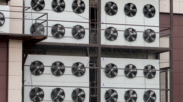 Air conditioner unit fan rotating. Industrial air conditioning sustem on the wall outdoors. 