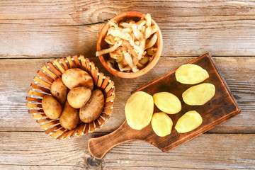 Men's hands clean potatoes for okroshki on an old wooden table.