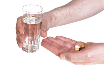Men hands with pills and glass of water isolated on white. Concept of healthcare, illness and treatment.