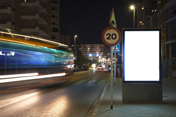 Advertising billboard near the road. White billboard. Blurred motion. Mock up.
