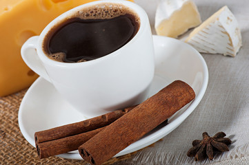 Food - a cup of hot coffee, soft light cheese covered with white mold on an old wooden background.