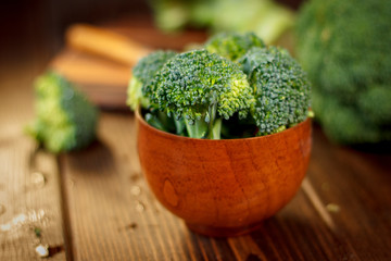 Broccoli crowns in a wooden bowl over table.