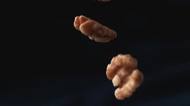 Pecan nuts and roasted corns falling. Shot with high speed camera, phantom flex 4K. Slow Motion.