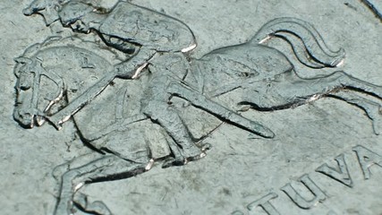 National symbols of Lithuania on the metal coin. The heraldic shield features a red field with an armored knight on a white horse holding a silver sword aloft in his right hand - Powered by Adobe