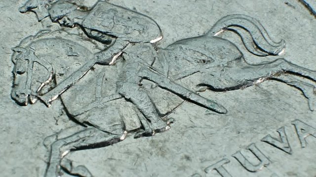National symbols of Lithuania on the metal coin. The heraldic shield features a red field with an armored knight on a white horse holding a silver sword aloft in his right hand
