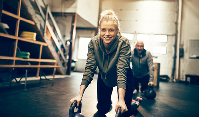 Smiling woman preparing to workout with weights at the gym