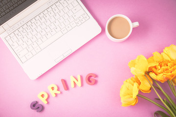 yellow tulips, laptop and coffee on a lilac background Spring, summer concept Flat lay Top view