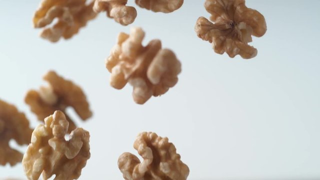 Camera follows walnuts in shell rolling on the table. Shot with high speed camera, phantom flex 4K. Slow Motion.