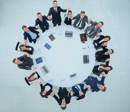 large business team sitting at the round table and raising his hands up