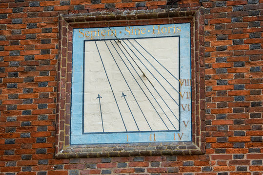 square blue and gold sun dial with roman numerals and words septem sine horis