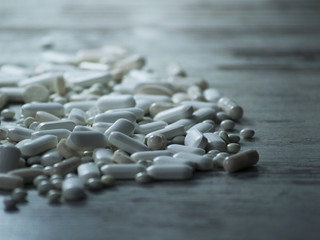 beaucoup de médicaments, de tablettes, de comprimes, de dragées blanches sur la table
