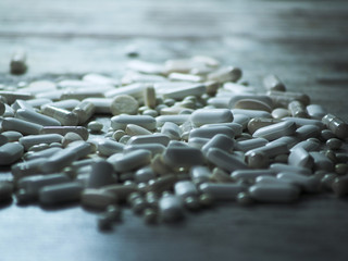 beaucoup de médicaments, de tablettes, de comprimes, de dragées blanches sur la table