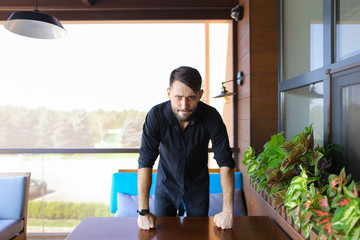 European businessman standing at office and wearing black shirt. Concept of responsibility and success, business.