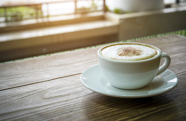 White cup of espresso coffee on wood table
