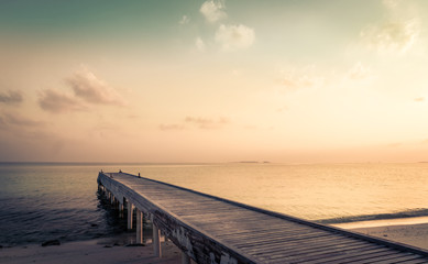 Obraz na płótnie Canvas Wooden jetty and amazing sunrise in Maldives