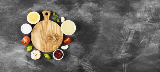 Various spices, herbs and vegetables on dark background. Top view, copy space. Food background