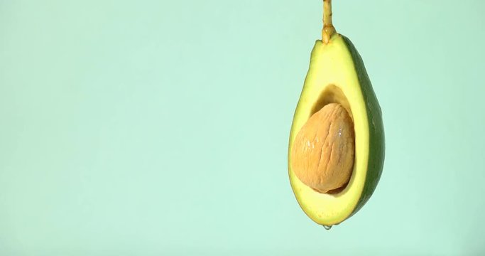 water or oils dropping on a avocado slice , fruit for diet and healthy food