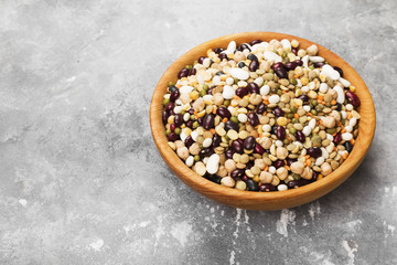Assortment of beans (red lentil, green lentil, chickpea, peas, red beans, white beans, mix beans, mung bean) on gray background. Copy space. Food background