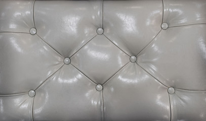 Coach-type screed. Retro light coloured chesterfield style quilted upholstery backdrop close up. Beige capitone pattern texture background.