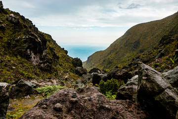 rocky mountain valley passage path among indonesian mountains with cloudy grey sky