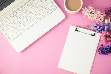lilac flowers, laptop and coffee on a lilac background Spring, summer concept Flat lay Top view Copyspace