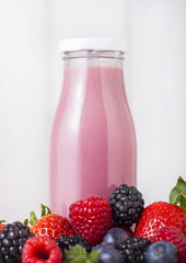 Glass bottle with fresh summer berries smoothie